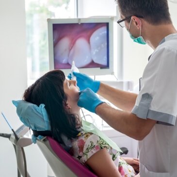 Dentist and patient looking at images captured by intraoral camera in Allen