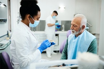 A dentist explaining the benefits of dentures in Allen